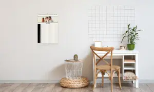 Schreibtisch mit Stuhl und Dekoelementen, Familienplaner als Wandkalender aufgehängt