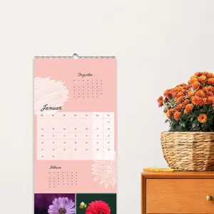 3-Monatskalender als Wandkalender 2026 an einer Wand und ein Sideboard mit Blumen